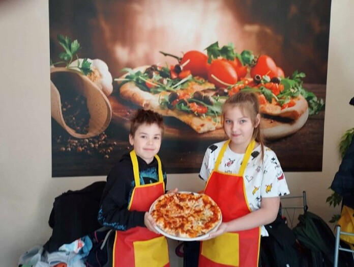 dzieci prezentują pizzę