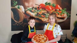 dzieci prezentują pizzę